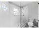 All-white bathroom with frameless glass shower, stylish tile floor, and octagon window at 2015 Cornell Pl, Port Orange, FL 32128