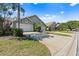 Street view of homes with well-manicured lawns, mature trees, and attached garages on a sunny day at 2015 Cornell Pl, Port Orange, FL 32128