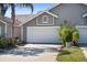 Attached two-car garage with neutral siding and an arched window detail above the garage door at 2015 Cornell Pl, Port Orange, FL 32128