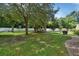 Expansive backyard features a lush lawn, mature trees, white fence, and outdoor seating area at 238 Crooked Tree Trl, Deland, FL 32724