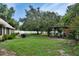 Lush backyard featuring mature trees, a cozy pergola with seating, and a grill area for outdoor entertainment at 238 Crooked Tree Trl, Deland, FL 32724