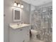 Well-lit bathroom featuring a vanity and a shower with a decorative, patterned curtain at 238 Crooked Tree Trl, Deland, FL 32724
