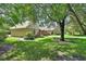 Side view of home with a detached garage and beautifully landscaped yard with large trees at 238 Crooked Tree Trl, Deland, FL 32724