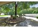 Well-manicured front yard features a small garden, mature trees, and a concrete driveway at 238 Crooked Tree Trl, Deland, FL 32724
