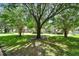 Lush front yard with mature trees casting shadows on the lawn in front of a well-maintained home at 238 Crooked Tree Trl, Deland, FL 32724