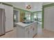 Bright kitchen with white cabinets, tile floors, green walls, and a center island at 238 Crooked Tree Trl, Deland, FL 32724