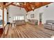 Bright open-concept living room featuring wood floors and tall ceilings with exposed beams at 238 Crooked Tree Trl, Deland, FL 32724
