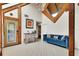 Bright sitting room featuring tile floors, wooden beams, and a cozy blue couch at 238 Crooked Tree Trl, Deland, FL 32724