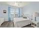 Relaxing bedroom with blue accents, ceiling fan, and lots of light at 2515 S Atlantic Ave # 401, Daytona Beach Shores, FL 32118