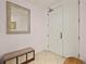 Inviting entryway with tile flooring, storage bench, decorative mirror and a solid door at 2515 S Atlantic Ave # 401, Daytona Beach Shores, FL 32118