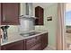 Well-appointed kitchen features a granite countertop, stainless steel hood, and cooktop at 2515 S Atlantic Ave # 401, Daytona Beach Shores, FL 32118