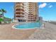 Resort-style pool with ocean views, lush landscaping, and plenty of deck chairs at 2515 S Atlantic Ave # 401, Daytona Beach Shores, FL 32118