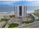 Stunning aerial view of a beachfront condo with pools, parking, and manicured landscaping at 2555 S Atlantic Ave # 1007, Daytona Beach Shores, FL 32118