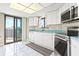 Bright kitchen featuring white cabinetry and stainless steel appliances, with sliding glass doors to a balcony at 2555 S Atlantic Ave # 1007, Daytona Beach Shores, FL 32118