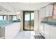 Kitchen with white cabinets opening onto a living area with ocean views and access to the balcony at 2555 S Atlantic Ave # 1007, Daytona Beach Shores, FL 32118