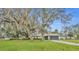 Inviting single-story home with mature shade trees, green lawn, and attached two-car garage at 2557 Shiprock Ct, Deltona, FL 32738