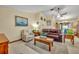 Comfortable living room featuring a ceiling fan, recliner, leather sofa, and light woodgrain floors at 2557 Shiprock Ct, Deltona, FL 32738