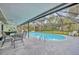 Screened-in pool features an oval design, metal ladder and nearby patio furniture at 2557 Shiprock Ct, Deltona, FL 32738