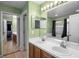 Bright bathroom features a double sink vanity, large mirrors, and access to the bedroom, adding both style and functionality at 2859 Doe Run Trl, Orange City, FL 32763