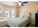 Inviting bedroom features a king bed, a ceiling fan, and natural light from the windows, offering a peaceful atmosphere at 2859 Doe Run Trl, Orange City, FL 32763