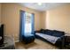 This cozy room features a comfortable sofa, ottoman, and window with blue curtains, creating a welcoming retreat at 2859 Doe Run Trl, Orange City, FL 32763