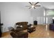 Inviting living room with ceiling fan, wood floors and cozy brown couches at 2859 Doe Run Trl, Orange City, FL 32763