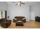 Inviting living room with ceiling fan, wood floors and cozy brown couches at 2859 Doe Run Trl, Orange City, FL 32763