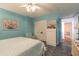 This bright bedroom has blue walls, a white dresser, closet, and tiled floors at 2967 S Atlantic Ave # 604, Daytona Beach, FL 32118