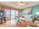 Bright living room featuring a ceiling fan, hardwood floors, ocean views, a cream couch, and a floral painting at 2967 S Atlantic Ave # 604, Daytona Beach, FL 32118