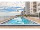 Outdoor pool overlooking the ocean, surrounded by lounge chairs and umbrellas at 2967 S Atlantic Ave # 604, Daytona Beach, FL 32118