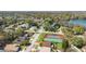 Aerial view showcases neighborhood homes, a lake, and recreational facilities, including tennis courts at 3021 Little Cypress Cv, Winter Park, FL 32792