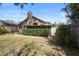 Backyard with a home featuring a chimney and a sliding glass door beneath a row of hedges at 3021 Little Cypress Cv, Winter Park, FL 32792