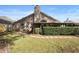 View of the back of the house with an enclosed patio and a trimmed hedge in the backyard at 3021 Little Cypress Cv, Winter Park, FL 32792