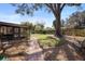Large backyard featuring a covered patio, mature trees, and a well-maintained lawn and landscaping at 3021 Little Cypress Cv, Winter Park, FL 32792