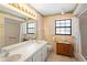 Well-lit bathroom with double sinks, framed mirror, and a bathtub-shower combo at 3021 Little Cypress Cv, Winter Park, FL 32792