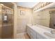 Bathroom with tiled floor, double sink vanity, framed mirrors, and enclosed shower at 3021 Little Cypress Cv, Winter Park, FL 32792