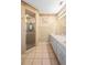 Bathroom featuring tiled floor, double sink vanity, enclosed shower with gold frame, and classic finishes at 3021 Little Cypress Cv, Winter Park, FL 32792