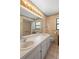 Well-lit bathroom with double sinks, framed mirror, and a bathtub-shower combo at 3021 Little Cypress Cv, Winter Park, FL 32792