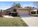 Well-maintained single-story home with a brick facade, two-car garage, and neatly trimmed front yard at 3021 Little Cypress Cv, Winter Park, FL 32792