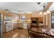 Well-lit kitchen and dining area featuring wood-look flooring, light wood cabinets, and white appliances at 3021 Little Cypress Cv, Winter Park, FL 32792