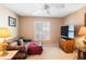 Comfortable living room features neutral colors, a ceiling fan, and a large window offering natural light at 3021 Little Cypress Cv, Winter Park, FL 32792