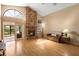 Open living room featuring vaulted ceilings, brick fireplace, and access to the sunroom at 3021 Little Cypress Cv, Winter Park, FL 32792