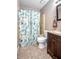 Bathroom with a vanity, sink, toilet, and shower with decorative shower curtain at 3057 Norlina St, Deltona, FL 32738
