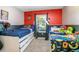 Bright bedroom featuring two twin beds, vibrant red accent wall, and natural light at 3057 Norlina St, Deltona, FL 32738