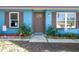 Inviting front entry featuring a brown front door, garden beds, stone accents and lush landscaping at 3057 Norlina St, Deltona, FL 32738