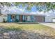 Charming one-story home with a blue exterior, green lawn and a driveway leading to a garage at 3057 Norlina St, Deltona, FL 32738