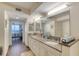 Bright bathroom featuring a granite countertop, dual sinks, and a serene view of the bedroom with ocean view at 3315 S Atlantic Ave # 705, Daytona Beach, FL 32118