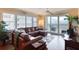 Bright living room showcasing a sectional sofa, ceiling fan, and windows with plantation shutters providing ample natural light at 3315 S Atlantic Ave # 705, Daytona Beach, FL 32118