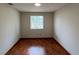 Clean and bright bedroom featuring laminate flooring, a window, and neutral walls providing a serene atmosphere at 3550 Forest Branch Dr # A, Port Orange, FL 32129