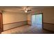 Comfortable bedroom with carpet flooring, wainscoting, a ceiling fan, and sliding glass doors to a screened-in patio at 3550 Forest Branch Dr # A, Port Orange, FL 32129